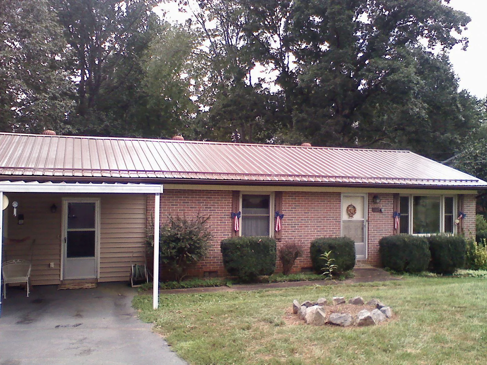 Bronze metal roof and carport on a brick ranch home — Roof Repair work by our crew in Swannanoa