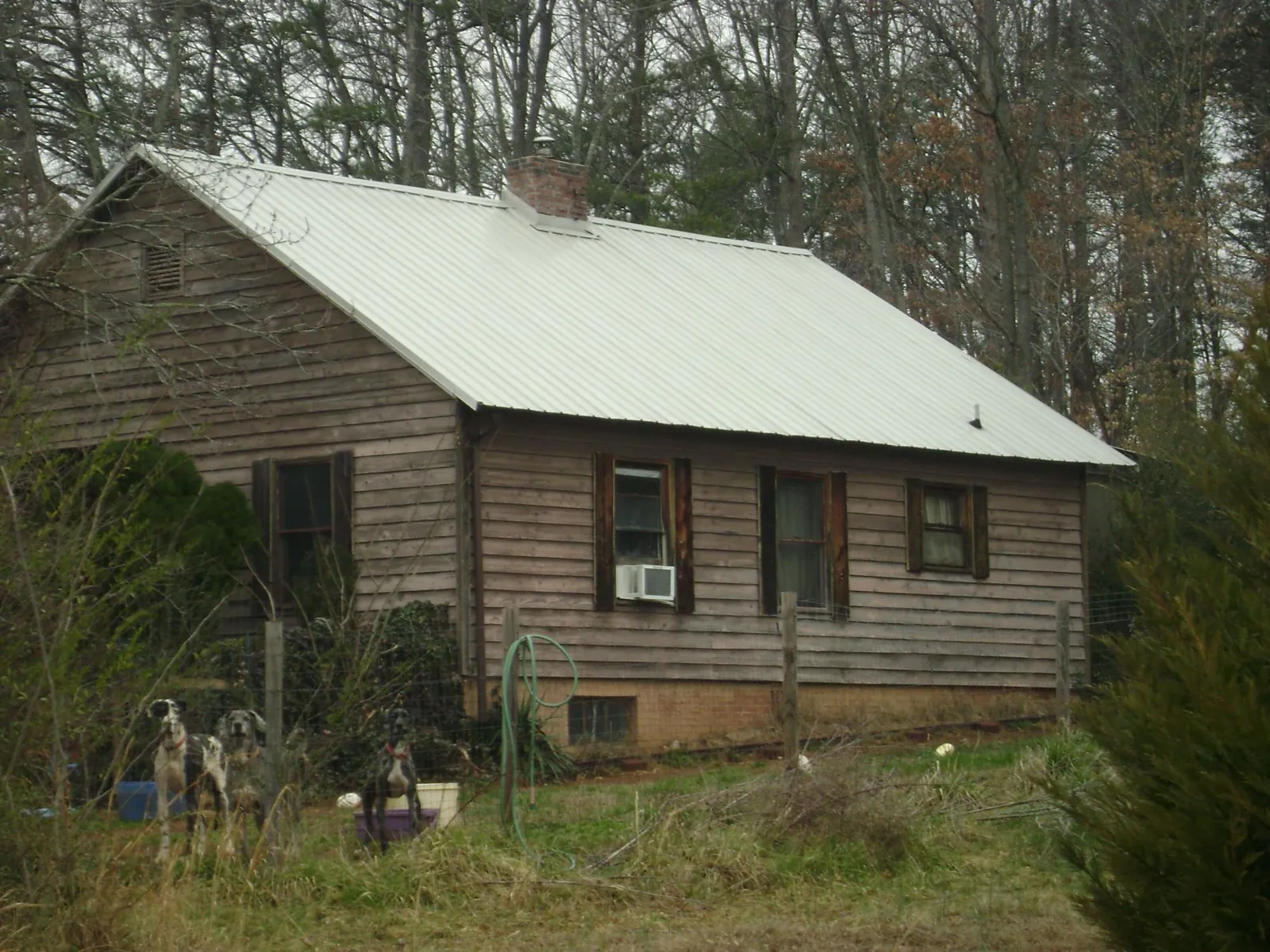 White metal roof on an old wood sided farmhouse, from a Metal Roof Installation job in Swannanoa